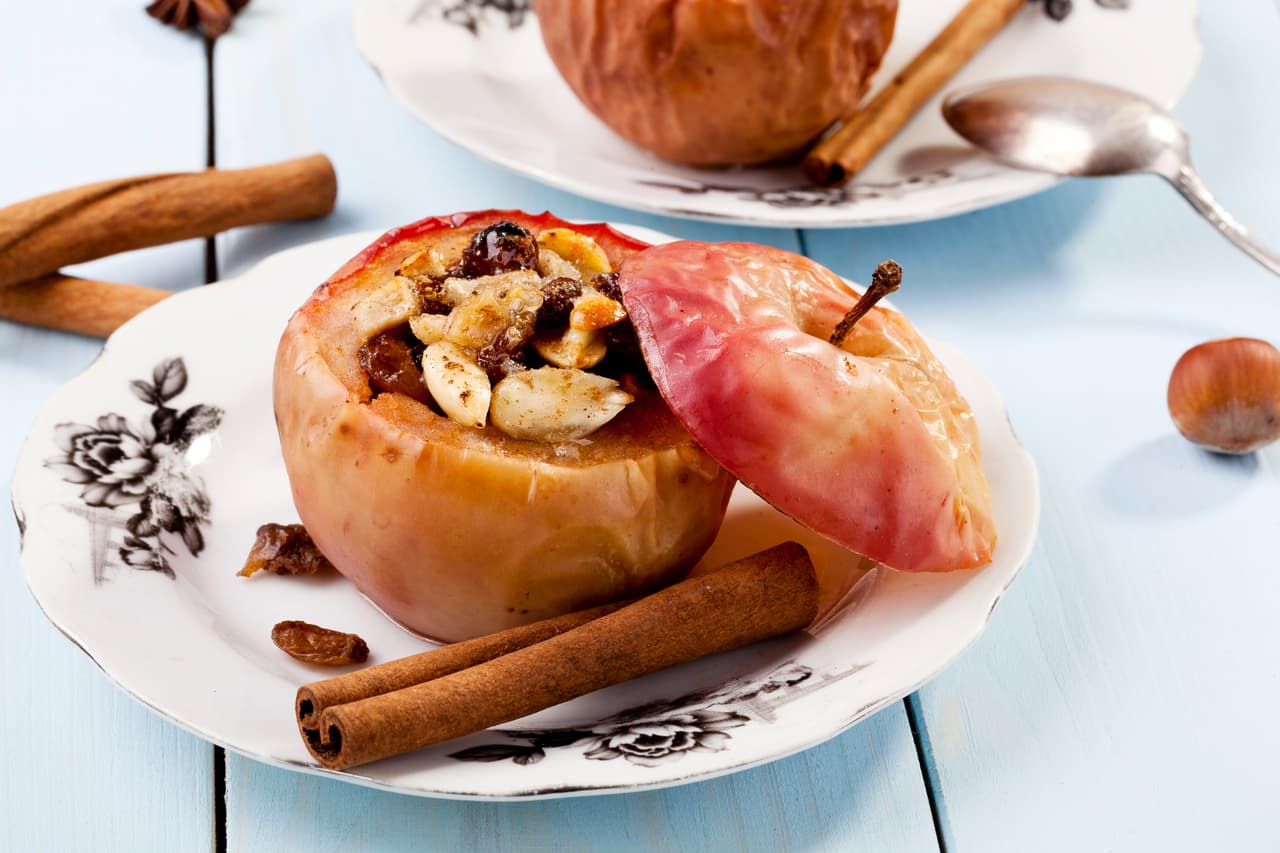 Manzanas asadas o al horno. Es tan sencillo como descorazonar la fruta e insertarle caramelo, azúcar y canela. Después, se hornean y se les da a tus invitados para robarles una sonrisa enorme.