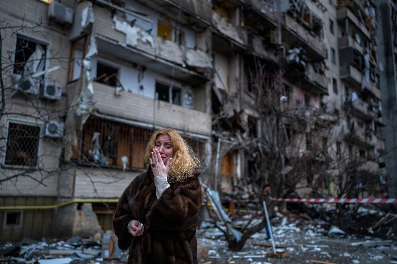 Natali Sevriukova se lamenta cerca de su casa tras un ataque con cohetes, el viernes 25 de febrero de 2022, en Kiev, Ucrania. (AP Foto/Emilio Morenatti)