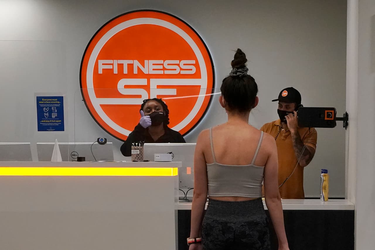 A la entrada del Fitness SF Transbay, los empleados de la recepción están encargados de revisar la temperatura de los clientes antes de que entren a sus instalaciones.