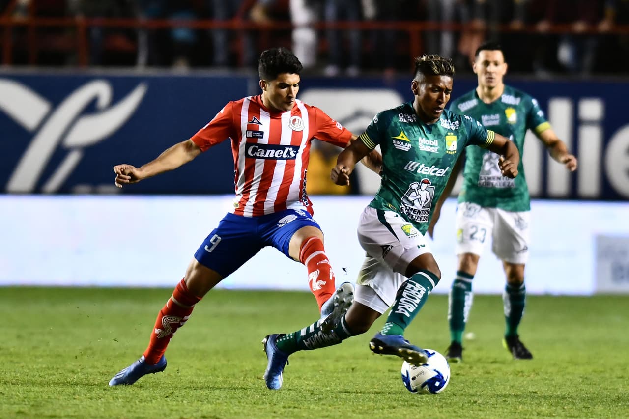 Nicolás Ibáñez presiona a Pedro Aquino en la salida del equipo de León.