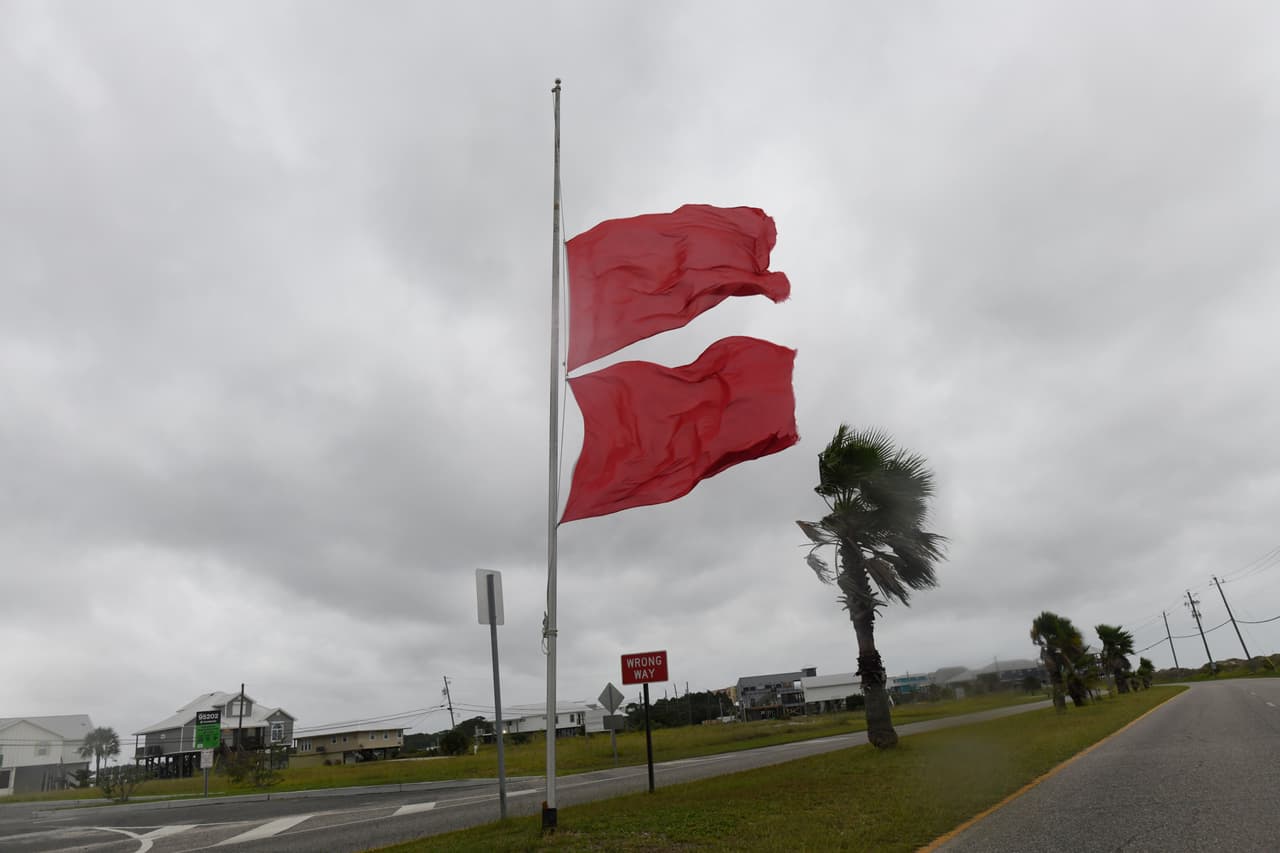 Banderas de la Marina ondean al viento mientras nubes amenazantes se ciernen sobre el lugar, generadas por los efectos de Isaias, el viernes 9 de octubre de 2026, en Dauphin Island, Alabama.