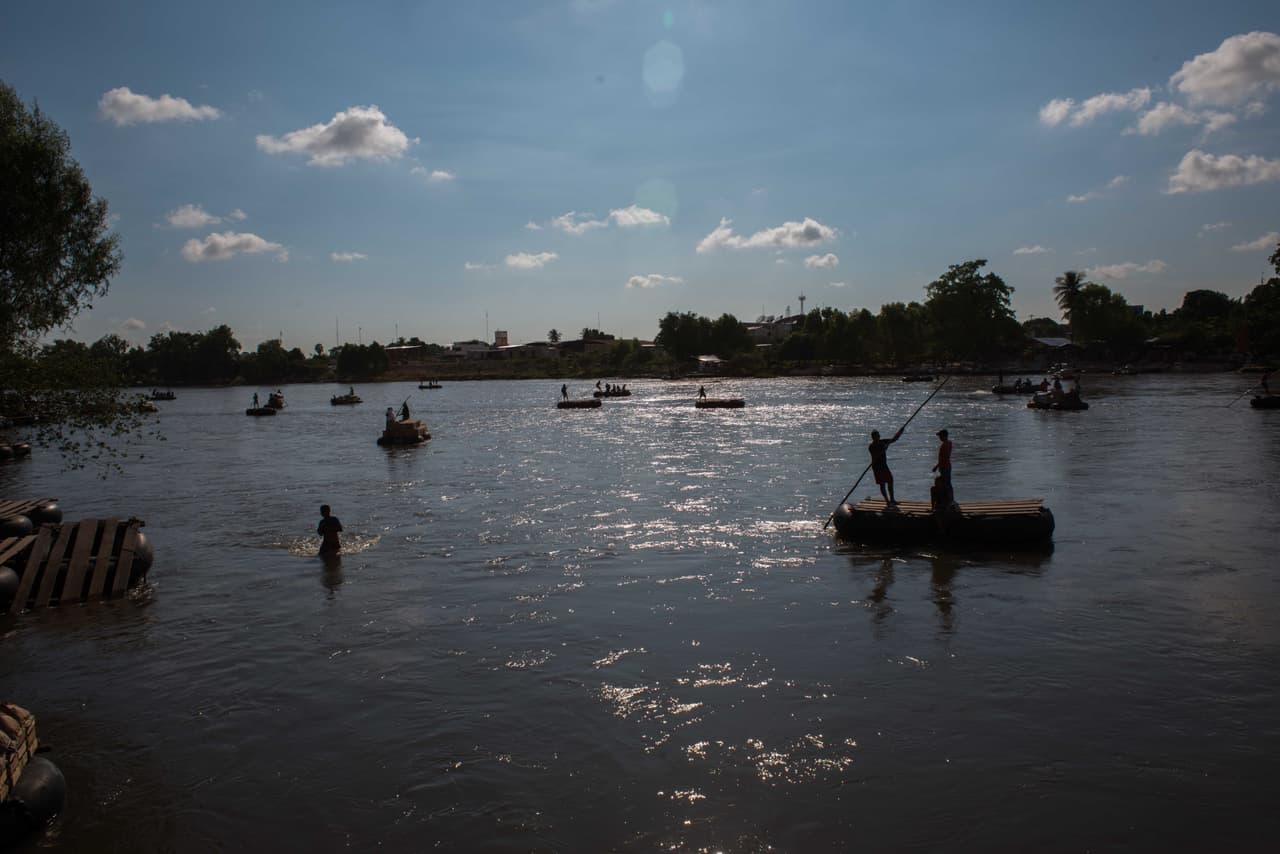 ￼Barcazas cruzan el río Suchiate que divide a Guatemala de México.