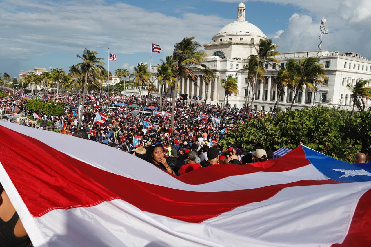 La multitud frente al capitolio de San Juan. Según la constitución un proceso de destitución puede darse solo si existen una de las causales de soborno, traición o delito grave o menos grave que implique depravación.