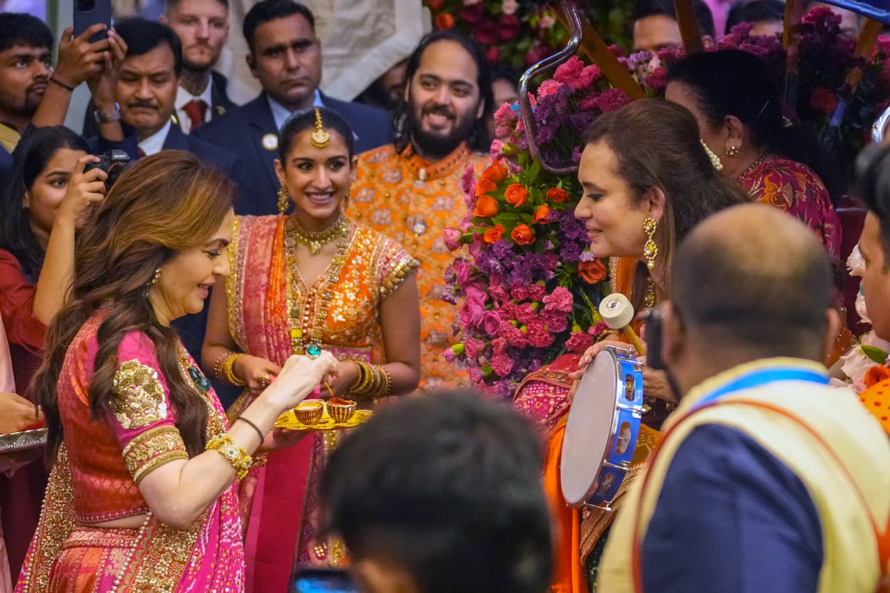 Nita Ambani, left, wife of Reliance Industries Chairman Mukesh Ambani along with his son Anant Ambani, right, and his fiancée Radhika Merchant, center, greets guests during pre-wedding ceremony at their residence Antilia in Mumbai, India, Wednesday, July 3, 2024.(AP Photo/Rafiq Maqbool)
