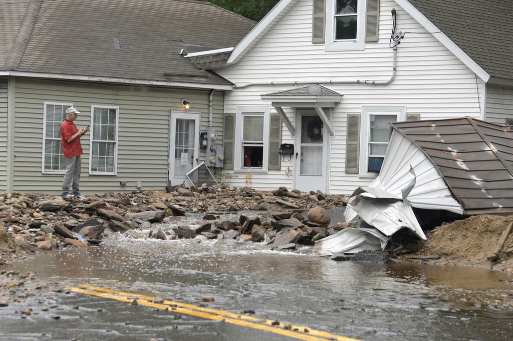 Un hombre examina los daños a una casa en Hamilton Street en Leominster, Massachusetts, después de que una fuerte lluvia cayera en la ciudad durante la noche.