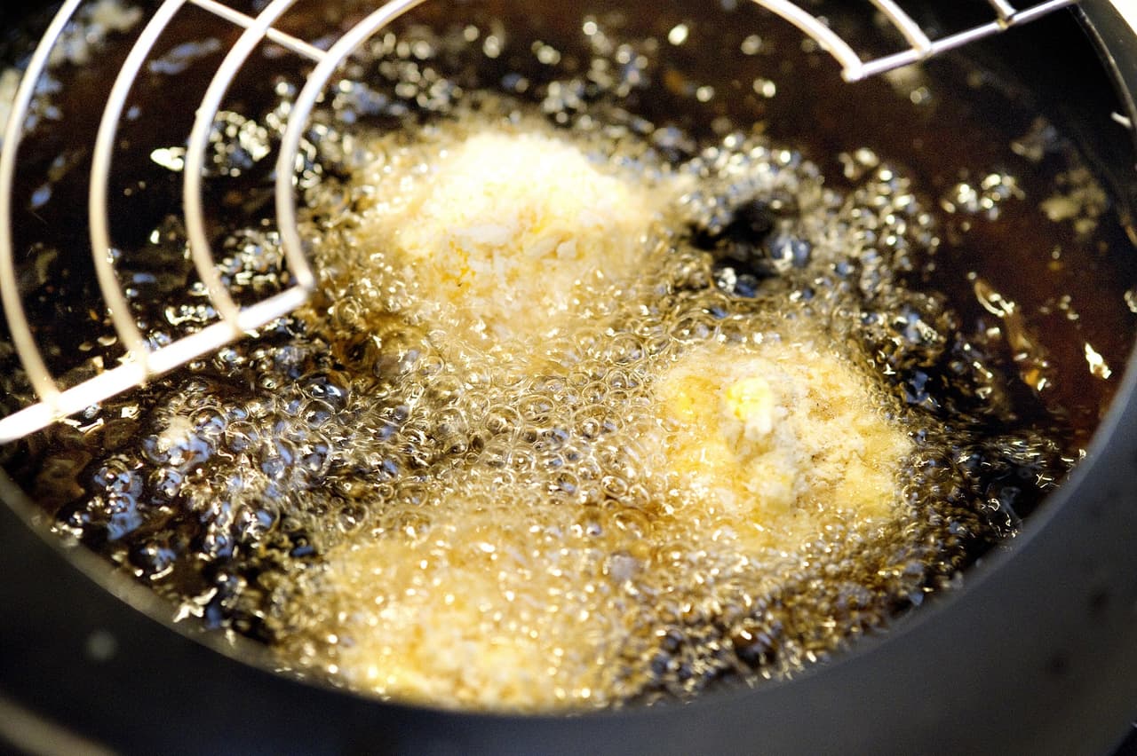 Calienta el aceite y fríe las croquetas por uno o dos minutos, dependiendo del tamaño. Escúrrelas en papel de cocina y sírvelas sobre la salsa.