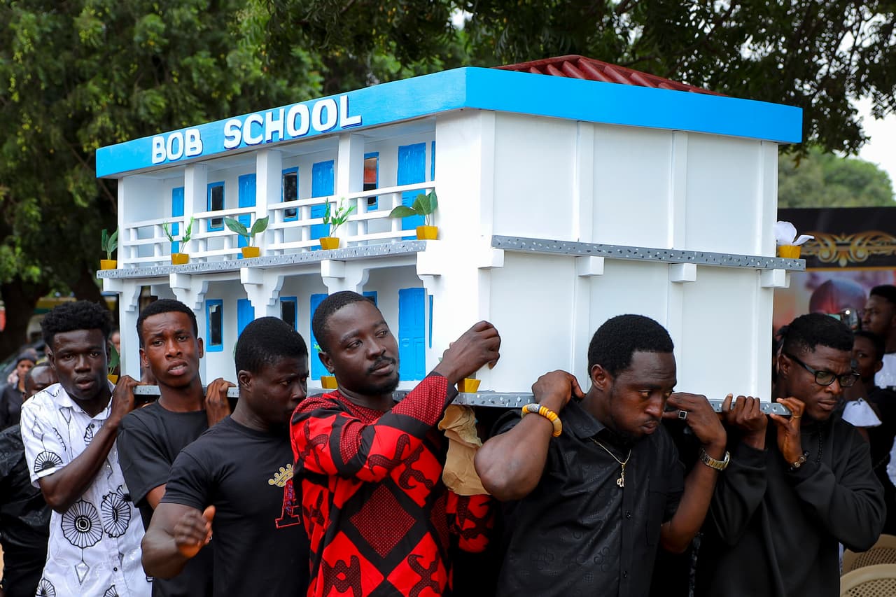 <b>El último homenaje a un hombre dedicado a la educación: </b>Varios hombres transportan el ataúd simbólico de Robert Nii Anang Obodai, antiguo propietario de una escuela, durante su funeral en Accra. La pieza forma parte de una tradición en la que incluso el ataúd puede convertirse en una representación de la vida del fallecido.