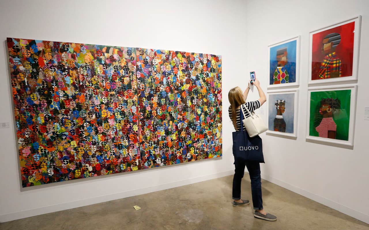 An art patron takes photographs on her cell phone in a gallery during Art Basel in Miami on November 30, 2016. Art Basel represents over 250 art galleries at the Miami Beach Convention Center and is considered one of the world's largest art festivals with art events throughout the city. / AFP / RHONA WISE / RESTRICTED TO EDITORIAL USE - MANDATORY MENTION OF THE ARTIST UPON PUBLICATION - TO ILLUSTRATE THE EVENT AS SPECIFIED IN THE CAPTION (Photo credit should read RHONA WISE/AFP/Getty Images)