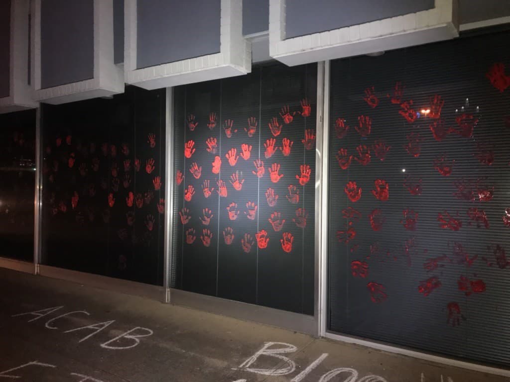 Dejan manchas de manos en pintura roja en la pared del edificio.