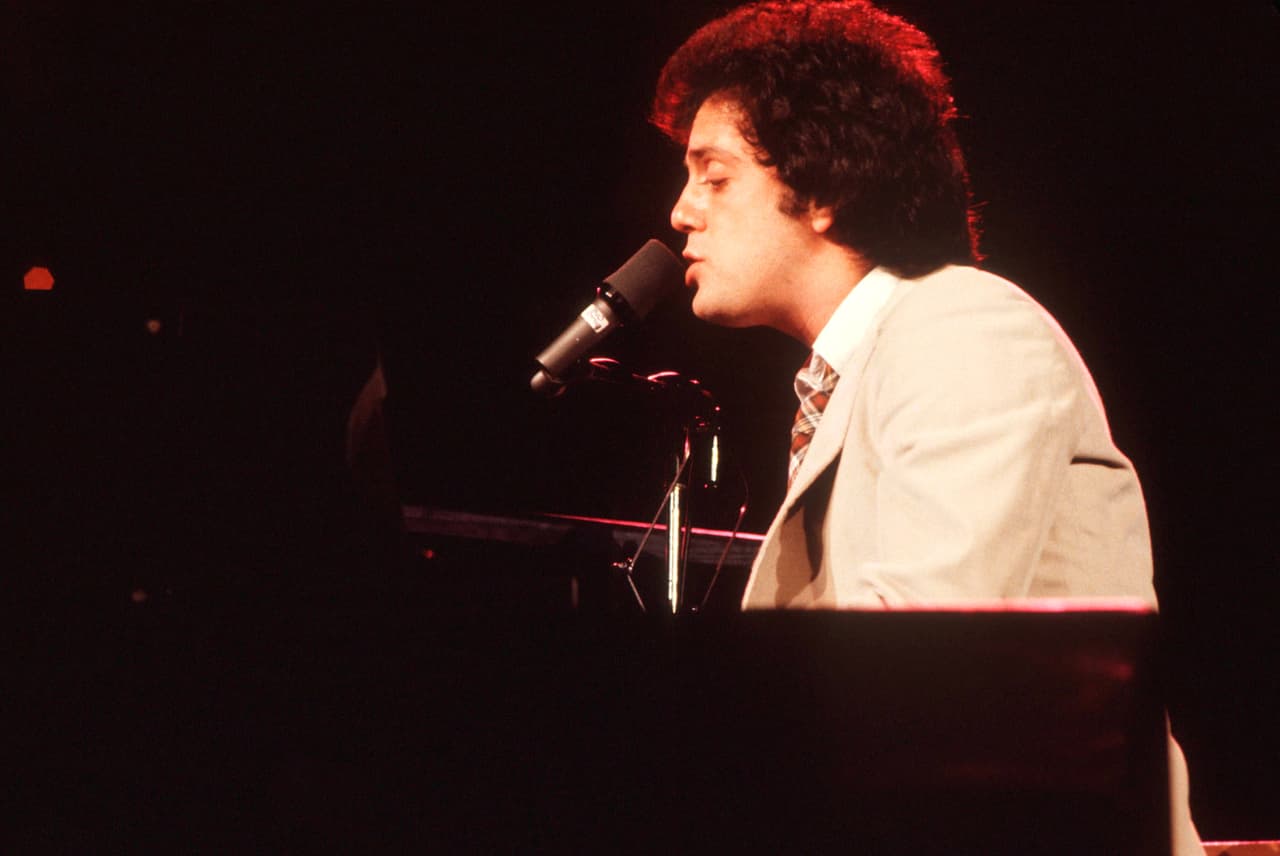 Billy Joel performs on stage, USA, 1977. (Photo by Michael Putland/Getty Images)