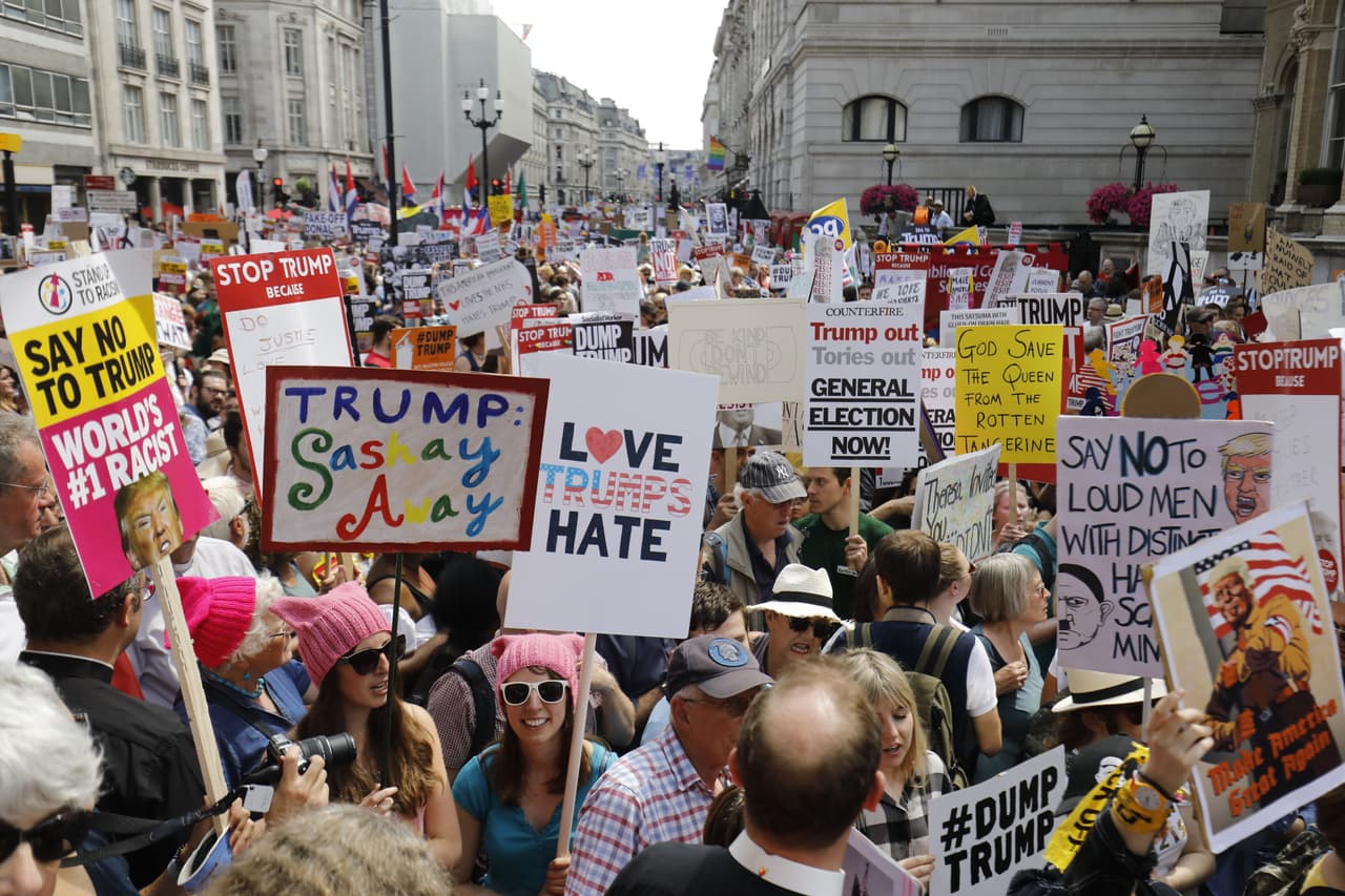 En un juego de palabras con el apellido del presidente: “El amor triunfa sobre el odio”. Más atrás en otro letrero dice: “Dios salve a la reina de la mandarina podrida”. “Este inmigrante estadounidense ama el servicio de salud británico (NHS) y odia a Trump”, al fondo.