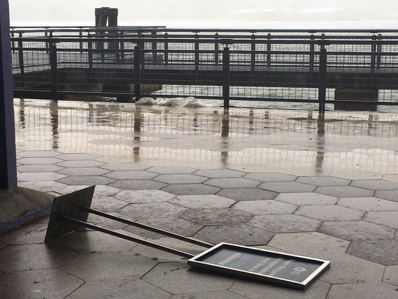 Grandes vientos en el área de South Street Seaport deja carteles en el piso.