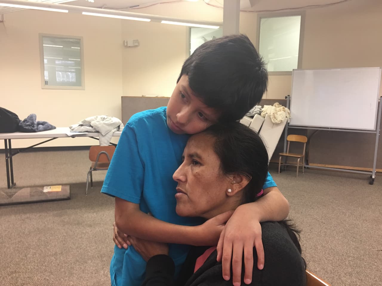 Abrazada por su hijo Roberto, de 10 años, quien suele tener pesadillas en las que agentes de ICE se llevan a su madre. (Patricia Vélez/Univision Noticias)