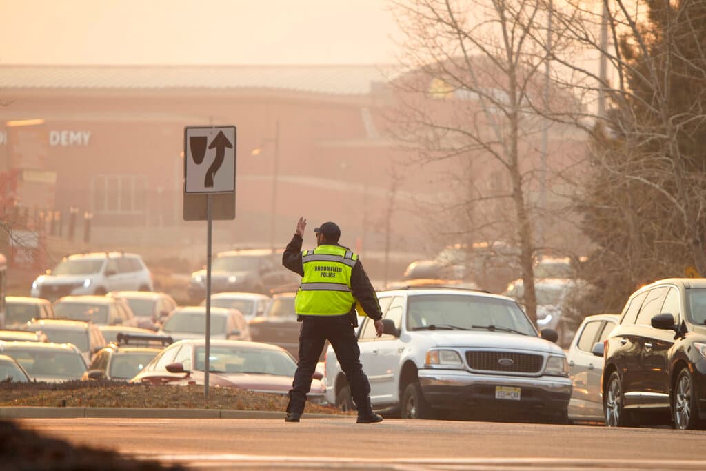 La policía de Broomfield dirige a los automovilistas durante una evacuación debido a un incendio forestal que arde cerca de un centro comercial el jueves 30 de diciembre de 2021.