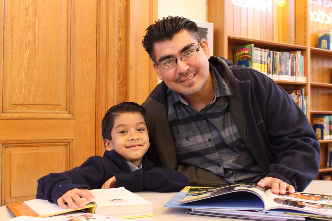 Participant parent, Leobardo Nova and son reading.