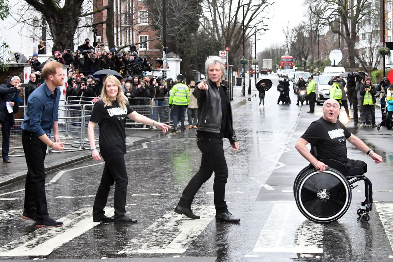 Este viernes, 
<b><a href="https://www.univision.com/famosos/meghan-markle-y-el-principe-harry-advierten-demanda-contra-los-paparazzi-y-sus-patrocinadores-en-canada-fotos">el papá de Archie Harrison</a></b> posó muy relajado junto a la directora musical Susan Warner, Bon Jovi y el veterano de las fuerzas armadas Andy Mudd, buscando recrear la icónica carátula de la producción Abbey Road, de los Beatles.