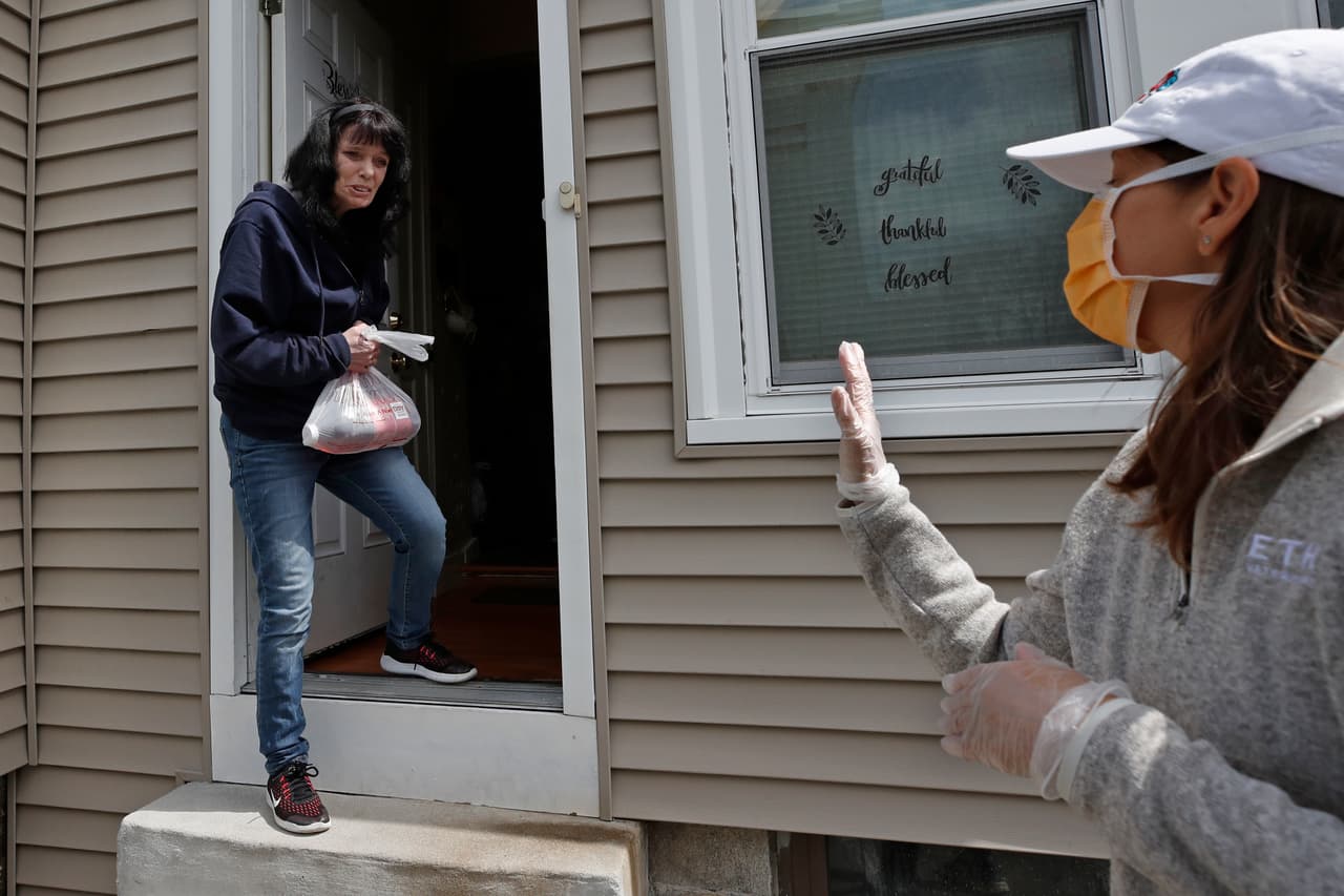 Una residente de Lawrence, Massachusetts, agradece a una voluntaria de ‘Neighbours in Need’ (vecinos necesitados, en español) al recibir un paquete de alimentos. Durante la cuarentena esta organización ha llevado alimentos gratis a unas 600 familias cada semana.