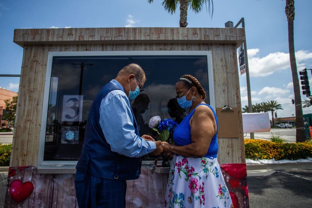 <b>Los detalles cuentan.</b> Michael Davis (izq.) le pone el anillo a su novia Natasha durante la ceremonia de su boda. Ambos usaron mascarillas durante la ceremonia civil efectuada en Anaheim, California. Y él le llevó a su nueva esposa un ramillete de flores. El condado de Orange clasifica en el número 8 de 3,109 condados respecto del número de bodas, según datos del 2019 del sitio The Wedding Report.