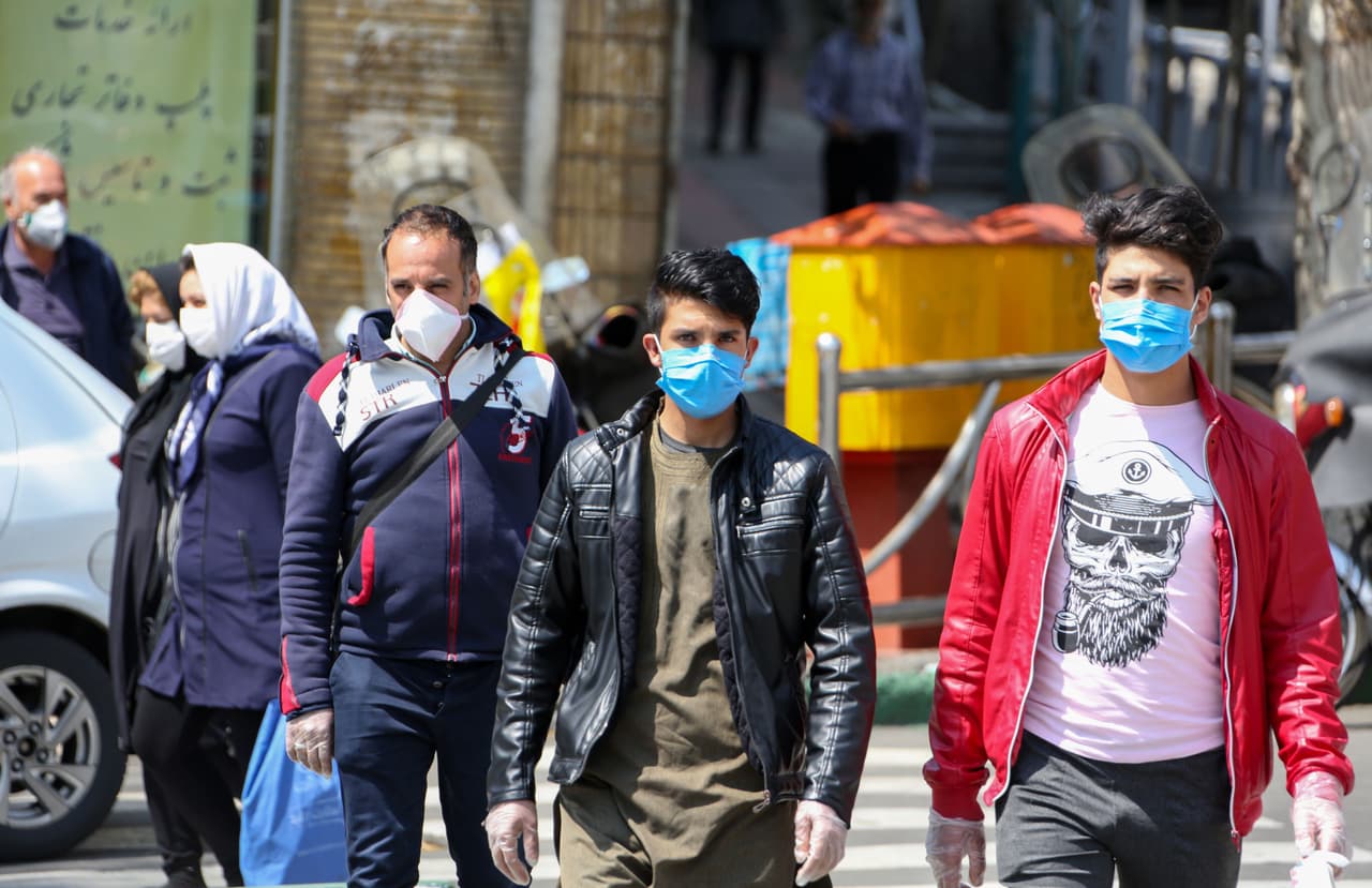 Iraníes caminan con mascarillas en Teherán.