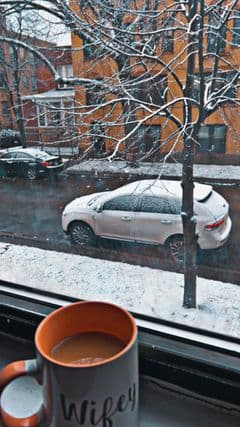Rossy Tovar disfruta con una tasa de café del paisaje blanco que cubrió su vecindario.