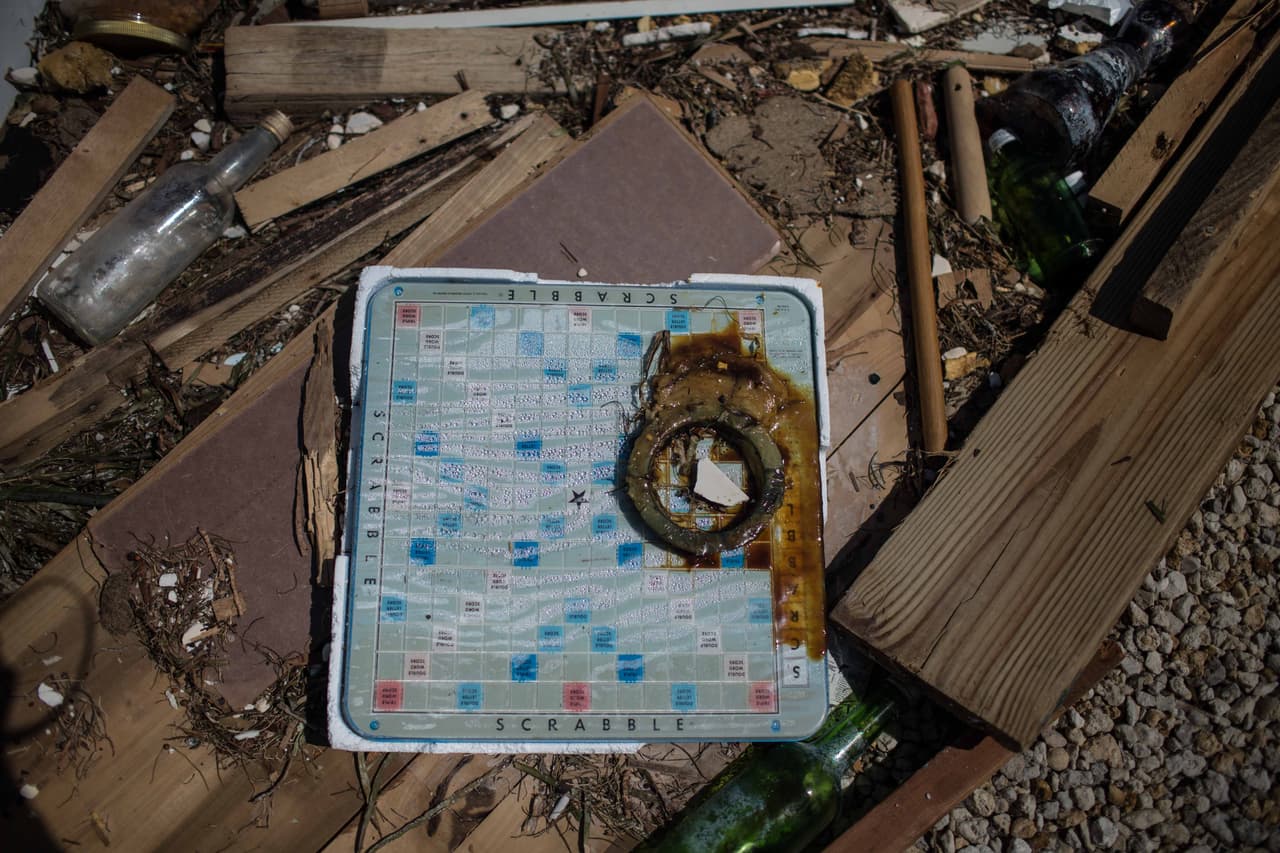 Un juego de mesa rodeado de maderas y desperdicios fuera de una casa. Almudena Toral/Univision Digital