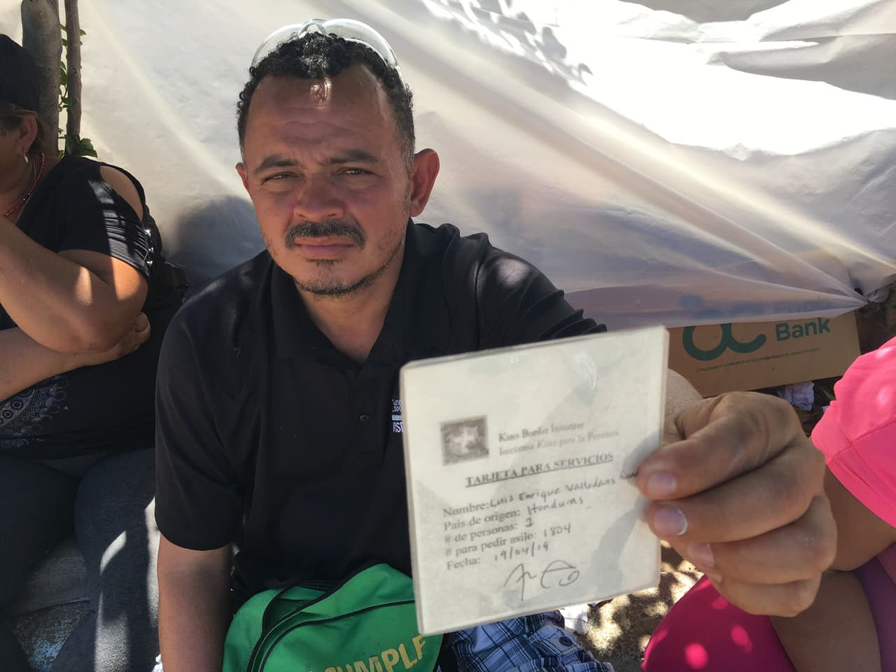 El hondureño Luis Valladares muestra la tarjeta que le entregó la organización que le dio alimentos en Nogales, México.