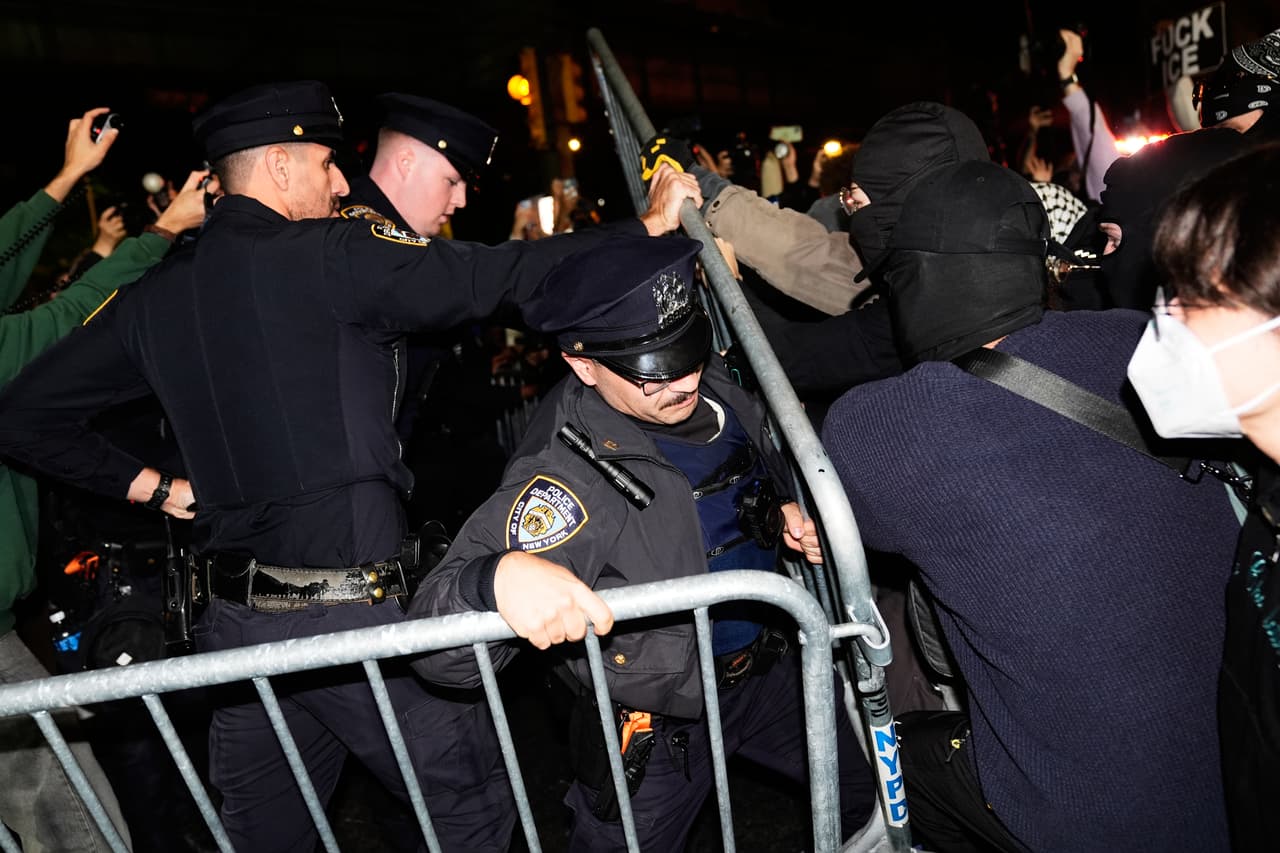 La policía de la ciudad de Nueva York intenta bloquear a los manifestantes cerca del lugar de un tiroteo el jueves 8 de octubre de 2026 en Nueva York.