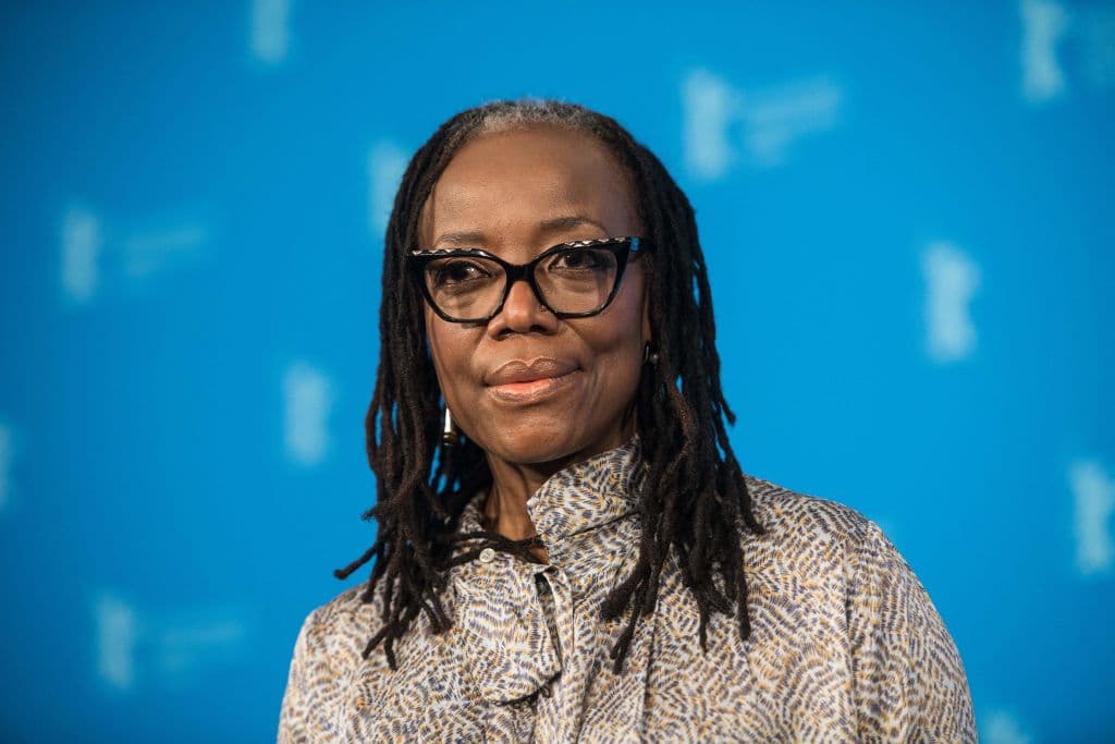 <b>Tsitsi Dangarembga</b> — directora, novelista y activista zimbabuense.
<br>
<br>En 2020, durante una protesta pacífica en Harare, Zimbabue, Dangarembga fue detenida mientras sostenía un cartel que decía: “Queremos algo mejor. Reformar nuestras instituciones”. Las organizaciones de derechos humanos, incluidas Amnistía y la asociación de escritores PEN International, habían pedido que se retiraran los cargos hasta que en septiembre pasado, fue puesta en libertad.