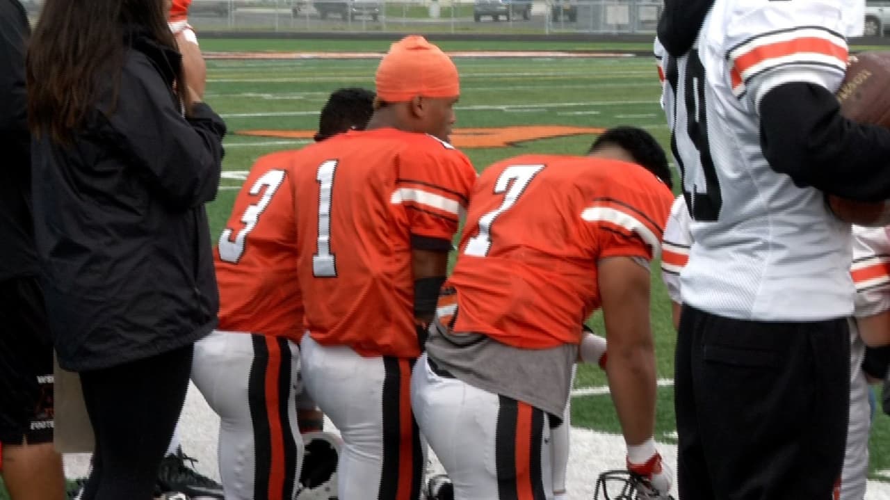 Muchos equipo de fútbol americano de high school en todo el país se han solidarizo con la misma pose durante el himno nacional.
