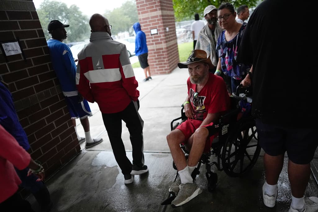 <b>La calma antes de la tormenta: </b>La gente disfruta del aire fresco en el exterior de la escuela secundaria Gibbs, un refugio antitormentas del gobierno donde 1,700 personas ya habían buscado refugio a última hora de la mañana, antes de la llegada del huracán Milton, en St. Petersburg, Florida, el miércoles 9 de octubre de 2024.