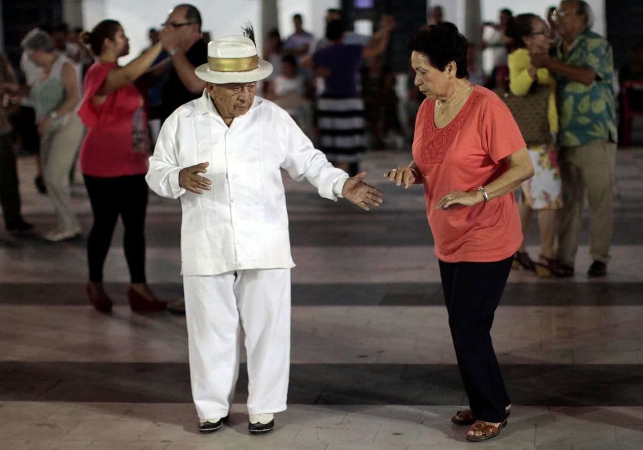 Varias parejas bailan danzón al caer la tarde en una plaza céntrica del Puerto de Veracruz.
