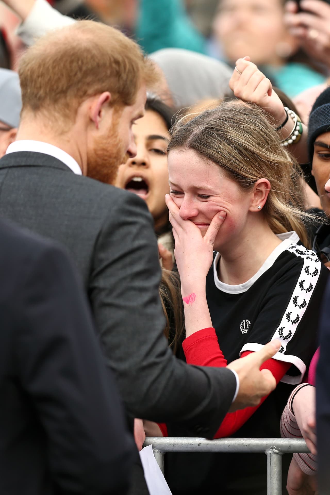 En esta imagen, se ve cómo Harry habla con ella brevemente, mientras qu ela joven se lleva la mano a la boca, emocionada.