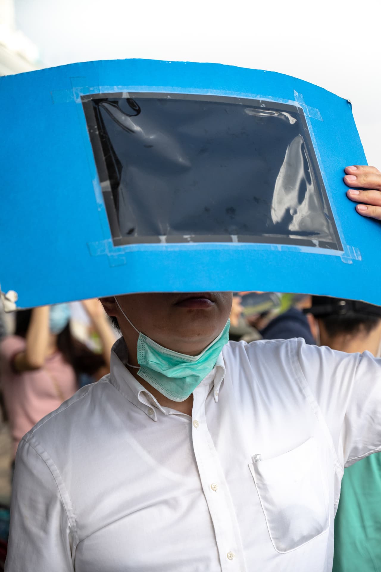 Personas empleando materiales oscuros y traslúcidos para observar el fenómeno desde Hong Kong, China.