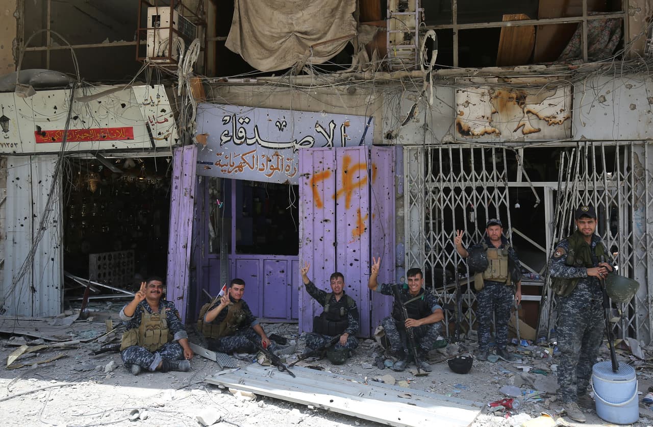 Los miembros de la policía federal iraquí muestran la señal de victoria en la Ciudad Vieja de Mosul el 8 de julio de 2017.