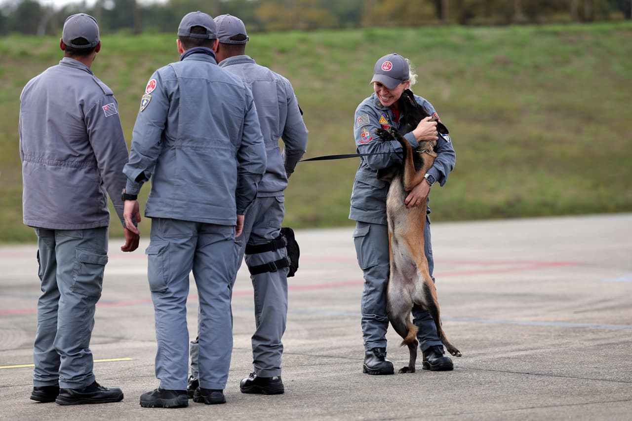 Una guía de equipos de búsqueda y rescate abraza a su perro antes de embarcar en un vuelo humanitario de la Fuerza Aérea Brasileña con destino a Venezuela, en la Base Aérea de Guarulhos, en São Paulo (Brasil), el viernes 26 de junio de 2026.