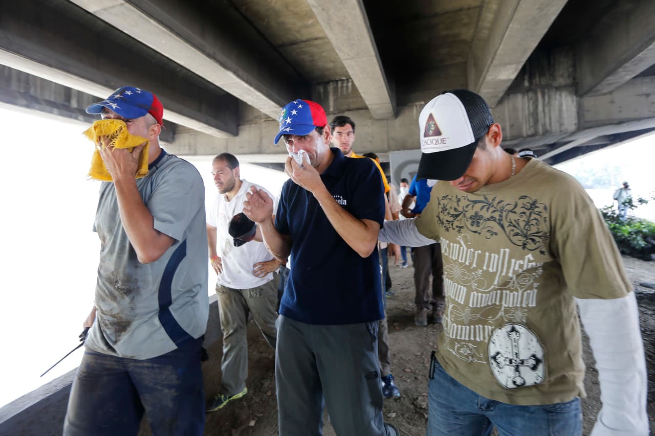Henrique Capriles, governor of the state of Miranda and opposition leader of the First Justice party, protects himself against the effect of tear gas below the highway. April 19, 2017.