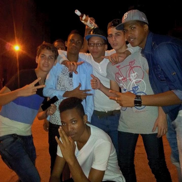 Leo, far left, Jhan Carlos, far right, and Samuel, crouching, pose with fellow mikis on Calle G.