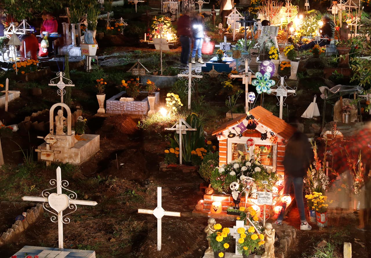 Velas encendidas y flores de cempasúchil adornan las tumbas de los cementerios mexicanos a los que acuden miles de personas para celebrar la arraigada tradición del 
<a href="https://www.univision.com/temas/dia-de-muertos">Día de Muertos</a>, en el que se dice que los difuntos regresan al mundo de los mortales.
