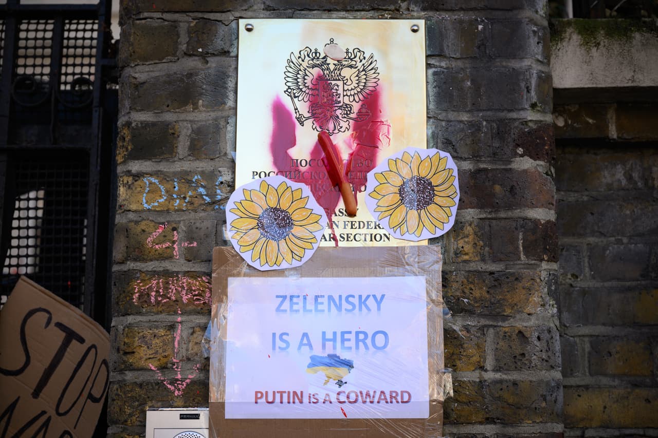 El emblema del girasol de la resistencia ucraniana se ve en las paredes de la embajada rusa en Londres, con un cartel debajo que dice: "Zelensky es un héroe, Putin es un cobarde", en referencia al presidente de Ucrania y el presidente de Rusia. 
<br>