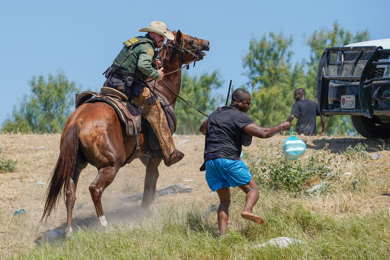 Un agente de la Patrulla Fronteriza a caballo usa las riendas para tratar de evitar que un migrante haitiano ingrese a un campamento a orillas del Río Grande, cerca del Puente Internacional Acuña del Río en Del Río, Texas. Las fotografías fueron tomadas el 19 de septiembre de 2021.
<br>