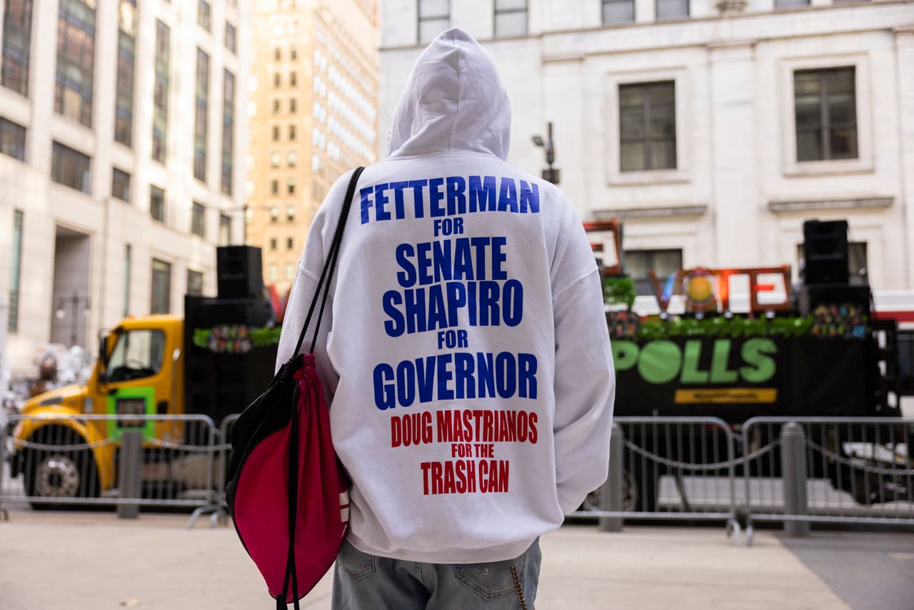 Un hombre parado frente al Ayuntamiento con una sudadera con capucha en apoyo de John Fetterman y Doug Shapiro, en Filadelfia.
