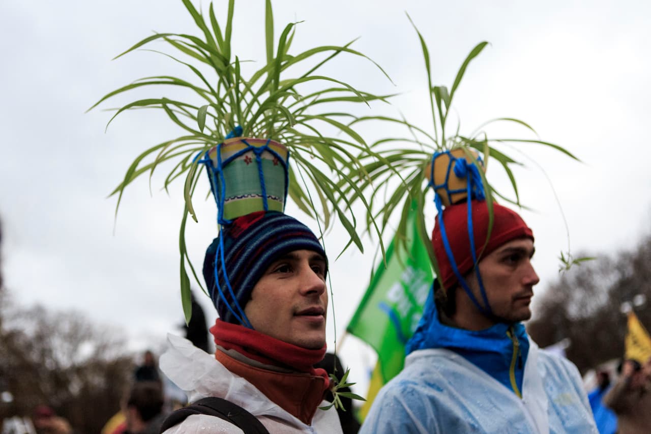 Estos manifestantes en Berlín llevan macetas con palmas sobre la cabeza.