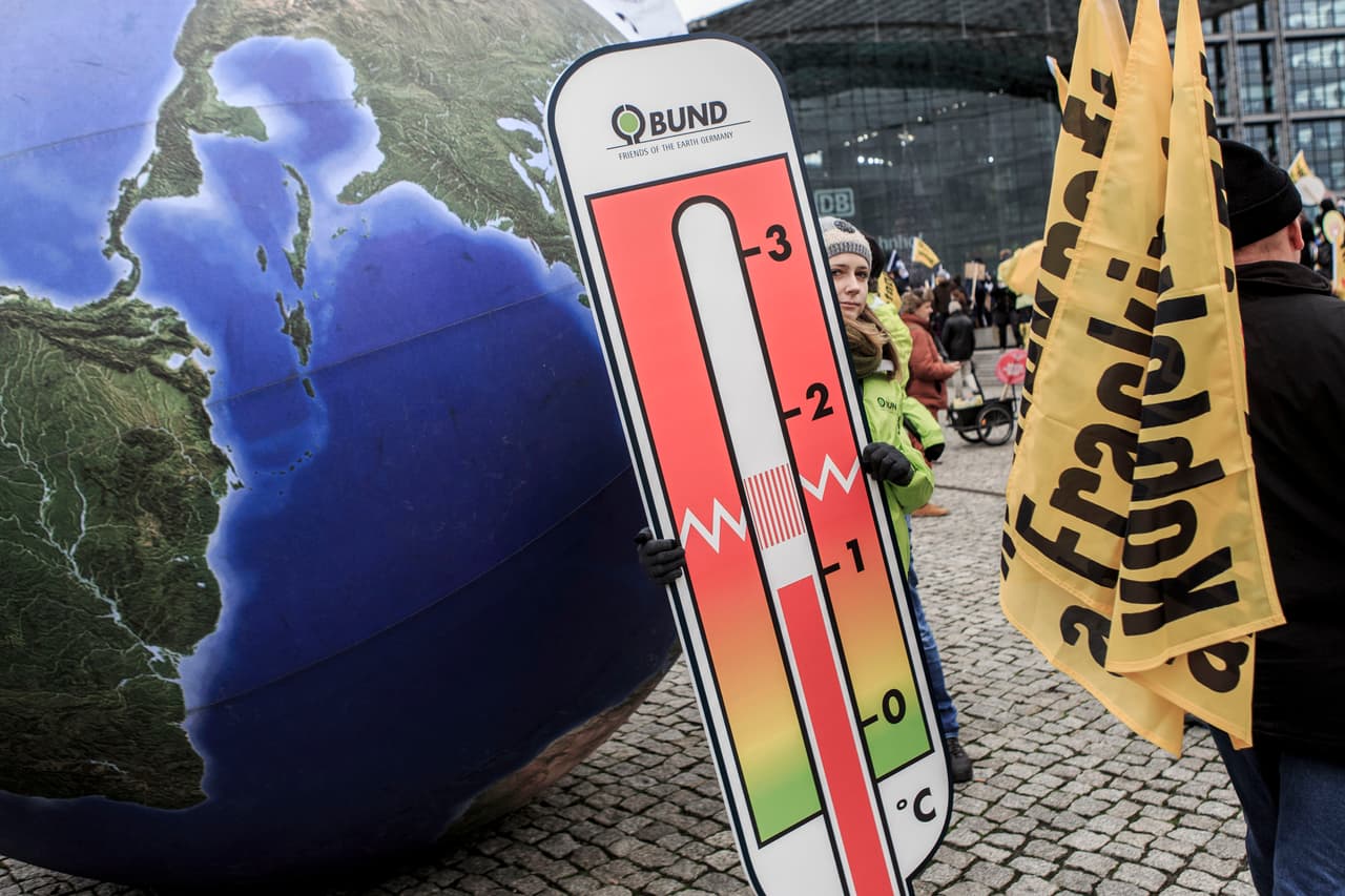Un modelo de la Tierra sostiene un termómetro. De esta forma, en Berlín tratan de llamar a los países a alcanzar un acuerdo sobre el cambio climático.