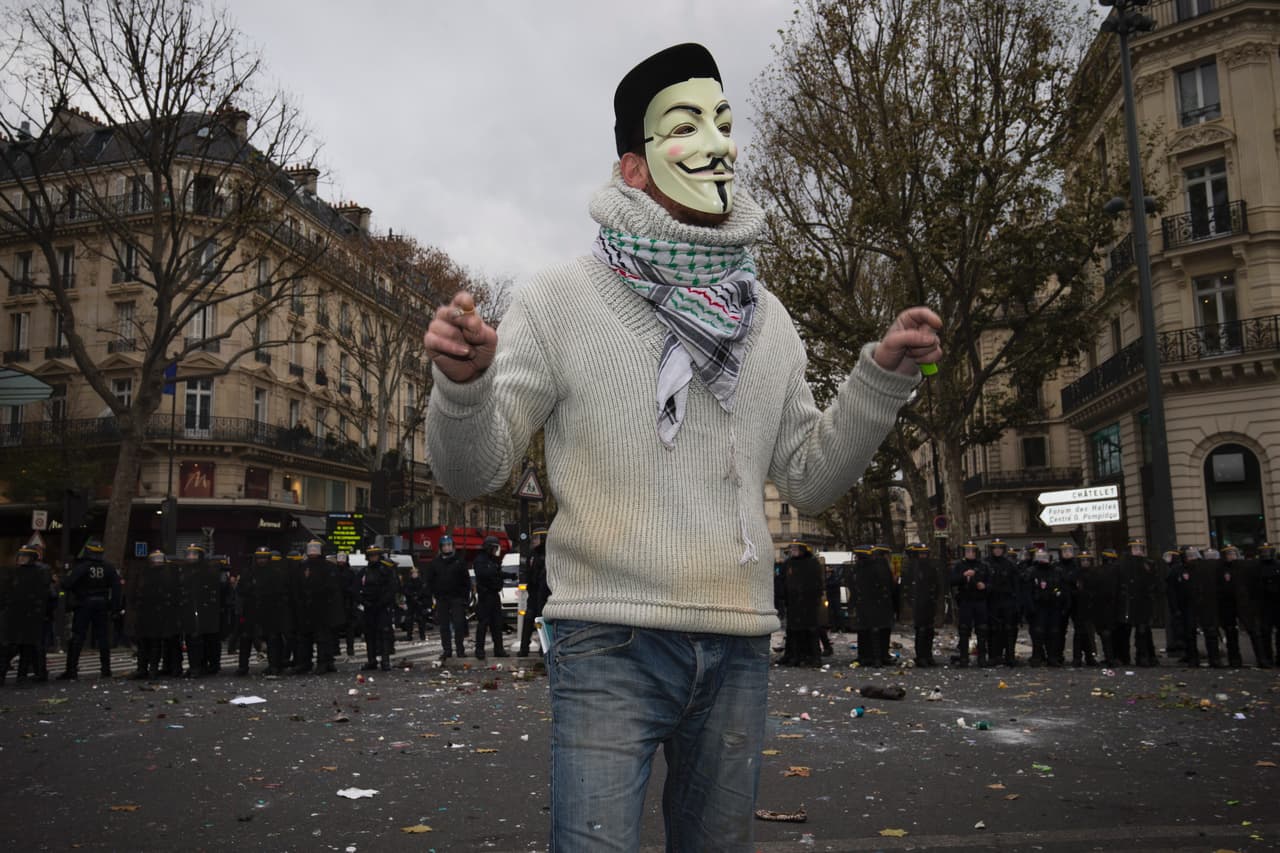París, sede del encuentro mundial, ha prohibido las manifestaciones. Este hombre con máscara se coloca delante del cerco policial.