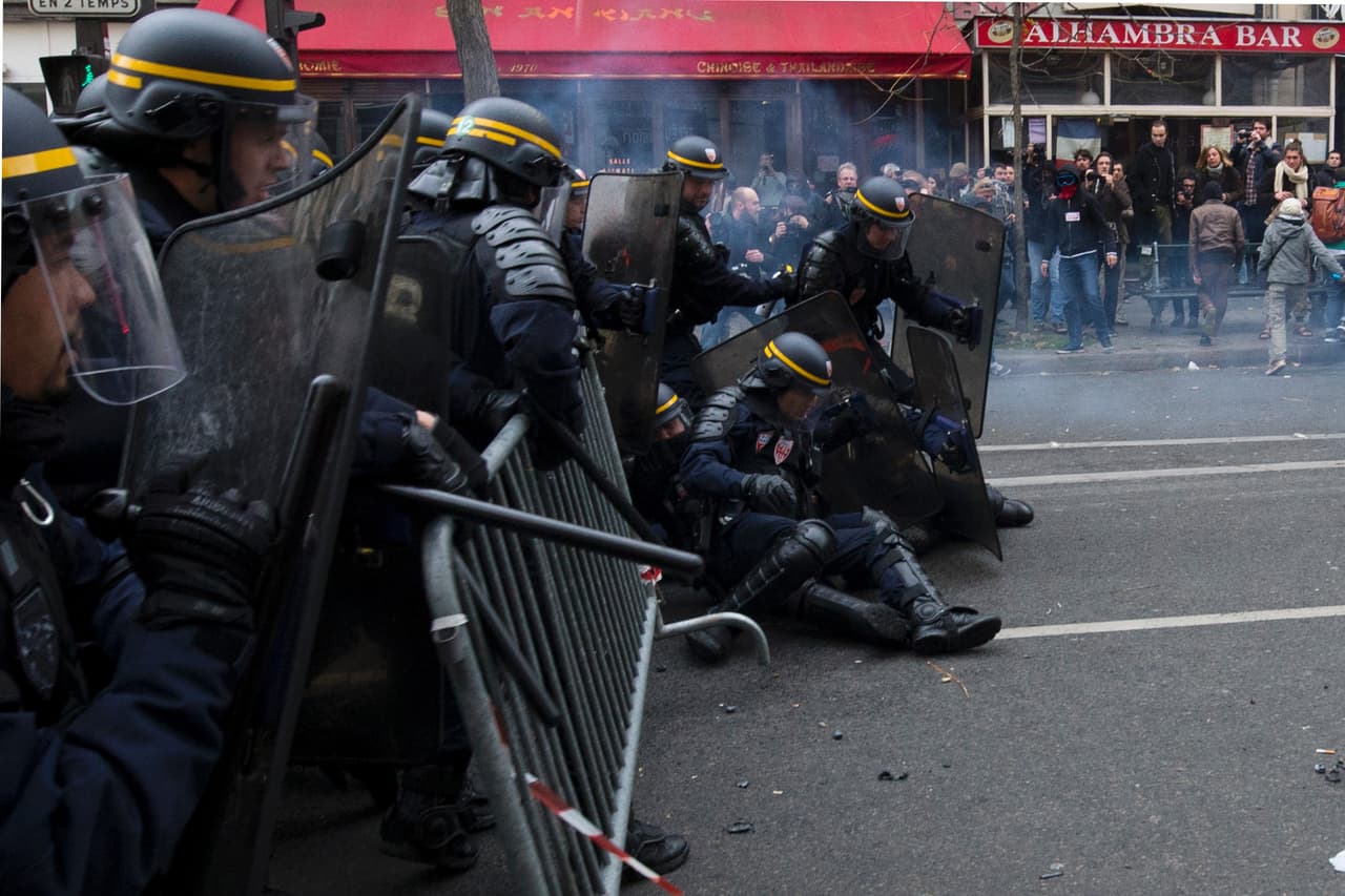 Miembros de la policía antidisturbios en París caen durante los enfrentamientos con manifestantes.