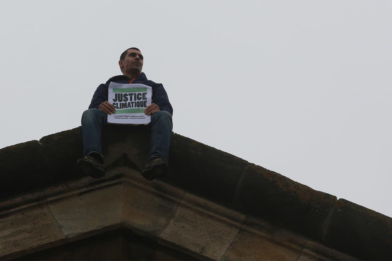 Un manifestante que pide "justicia climática" se sentó en la cima de la Puerta de la Victoria en Burdeos.