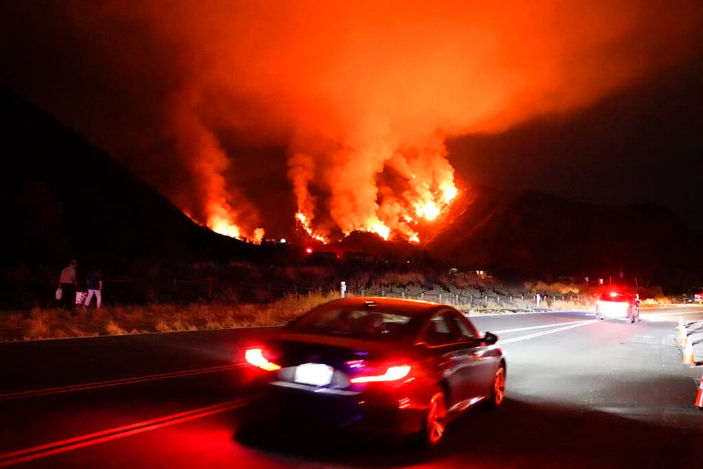 Conductores se abren paso en una carretera en una zona de incendios, el jueves 13 de agosto de 2020, en Azusa, California. (AP Foto/Marcio Jose Sanchez)