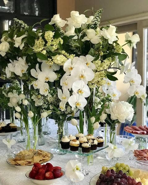 En la celebración hubo una mesa con bocadillos y flores por todos lados.