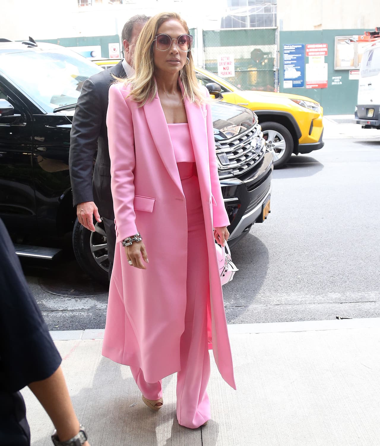 <b>Look 7</b>
<br>Como parte de la promoción de la cinta, Jennifer López se paseó en un autobús abierto vestida totalmente en rosa chicle. Usó pantalones, crop top y abrigo del diseñador australiano Alex Perry.