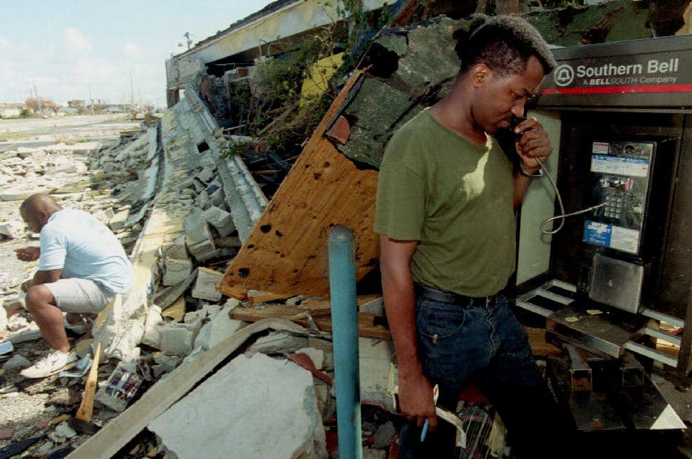 A man tries to use a public telephone in Miami afrer Hurricane Andrew.